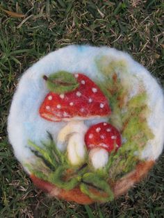 two mushrooms sitting in the grass on top of a plate