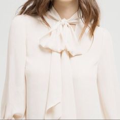 A Sophisticated, Ladylike Dramatic Bow Detail Infuses Our Sheer Split-Neck Blouse With Feminine Flair. Elegant Spring Tie Neck Blouse, Feminine Tie Neck Top For Evening, Elegant Spring Blouse For Brunch, Elegant Tie Neck Tops For Spring, Elegant Tie Neck Blouse For Brunch, Elegant Blouse For Spring Brunch, Elegant Beige Tie Neck Blouse, Chic Beige Blouse, Chic Spring Tie Neck Blouse