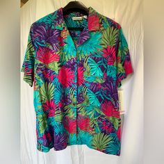 Blue, Green, Pink, Purple, Frond Button Down Hawaiian Shirt. 55% Cotton, 45% Rayon. Tropical Multicolor Button-up Shirt, Multicolor Tropical Button-up Shirt, Green Tropical Print Button-up Top, Multicolor Tops With Button Closure For Vacation, Purple Short Sleeve Beach Blouse, Purple Short Sleeve Blouse For Beach, Purple Short Sleeve Top With Button Closure, Multicolor Tropical Print Button-up Camp Shirt, Purple Short Sleeve Blouse For Vacation