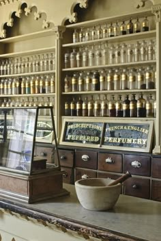 an old pharmacy with many bottles on the shelves and a mortar bowl in front of it