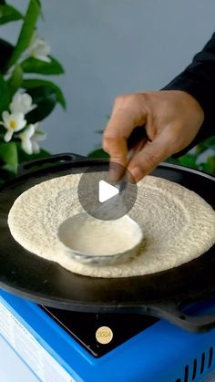 a person using a skillet to make tortilla