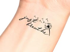 a woman's wrist with a dandelion tattoo that reads, happy mother