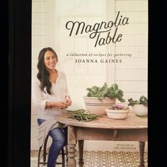 a woman sitting at a table in front of a book