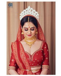 a woman wearing a red and gold bridal outfit with a tiara on her head