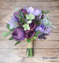 a bouquet of purple flowers on a wooden surface