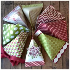 paper christmas trees are arranged in a circle on a wooden floor with red bows and polka dots