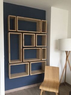 a wooden chair in front of a blue wall with bookshelves on the side