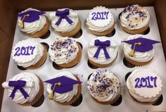 cupcakes decorated with graduation caps and tassels are displayed in a box