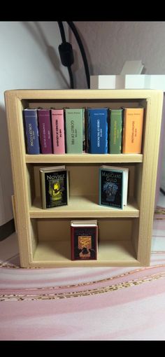 a book shelf filled with books on top of a bed