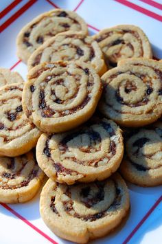 a plate full of cookies with chocolate swirls on top and red stripes around the edges