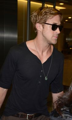 a man in sunglasses is walking through an airport