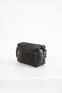 Natural grain leather toiletry bag, lined with cotton fabric. Wide-open interior for easy access to toiletries and other daily essentials. Featuring two zippered exterior pocket. Leather Toiletry Bag, Leather Dye, Daily Essentials, Vegetable Tanned Leather, Toiletry Bag, Small Bags, Easy Access, Black And Brown, Caramel