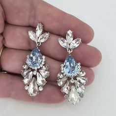 "Elegant Vintage style Bridal Earrings. Made with high-quality Crystal rhinestones in light blue and clear crystals. Gorgeous and elegant floral-inspired drops. Pair them with a cocktail dress or an over-sized sweater for an everyday look. Rhodium silver plated 2\" length, 1\" width Glass crystals Surgical steel posts, hypoallergenic" Blue Rhinestone Crystal Earrings For Wedding, Blue Statement Earrings, Blue Chandelier, Anchor Earrings, Gold Belts, Vintage Bridal, Clear Crystals, Large Earrings, Large Crystals