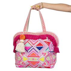 Discover the latest gem in Katydid Wholesale's lineup: the multicolored aztec fringe tote bag for women. This exquisite tote is graced with a unique design, crafted exclusively by Katydid, ensuring that your boutique stands out from the rest. Its mesmerizing pattern showcases a lively blend of vibrant embroidery and an elegant pink frill along the top edge. The crowning glory is the large white tassel, playfully decorated with a charming yellow pom-pom, adding a dash of whimsy to your collection Multicolor Festival Tote Beach Bag, Multicolor Tote Beach Bag For Festivals, Pink Rectangular Tassel Bag, Rectangular Pink Bag With Fringe, Bohemian Style Multicolor Shopping Bag, Pink Bags With Tassels For Daily Use, Trendy Tote Bag For Festivals, Trendy Multicolor Tassel Bags, Trendy Multicolor Fringe Bag