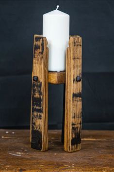 a white candle sitting on top of a wooden stand