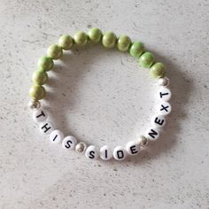 "A pretty beaded breastfeeding reminder bracelet. The bracelet consists of pale green acrylic beads. The coloured beads are known as miracle beads which are a type of resin bead with a lacquered surface which makes them incredibly shiny. They almost look like a bead within a bead. The beads measure approximately 8 mm. The bracelet measures 7 inches but as it is made from elastic it will stretch to accommodate most wrist sizes. There are silver plated spacer beads between the lettering. The wording on the bracelet reads \"This Side Next\". If you forget which side your baby has last fed from this bracelet can help. As it is a stretch bracelet made from elastic it is easy to swap form one wrist to the other, simply roll down over your wrist to avoid overstretching the bracelet. You bracelet Green Name Bracelet With Letter Beads, Green Personalized Bracelets With Round Beads, Personalized Green Bracelets With Round Beads, Personalized Green Bracelets For Friendship, Everyday Green Stretch Bracelet With 8mm Beads, Green Beaded Name Bracelet For Friendship, Green Hypoallergenic Friendship Bracelets, Personalized Green Beaded Bracelets For Friendship, Hypoallergenic Green Friendship Bracelets