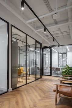 an empty office with wooden floors and glass walls