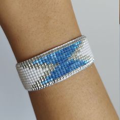 a woman's arm with a blue and white bracelet on it