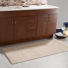 a bathroom with two sinks and a rug on the floor