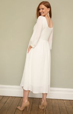 Feel fabulously feminine in our softly tailored and lightweight midi maternity dress in sheen ivory. Featuring a gently sheer pleated jersey, this maternity midi style is your go-to either for understated bridal chic, evening glamour or simply a relaxed vibe. You choose. Designed with a scooped neckline, cuffed sleeves, pleats across the empire line and a swishy skirt with concealed pockets for extra 'cool'. Soft sheen pleated jersey in ivory Scooped neckline front and back Bell sleeves finished Chic Pleated Midi Dress For Bridesmaids, Feminine Empire Waist Midi Dress For Brunch, Elegant Maternity Midi Dress, Pleated Midi Dress For Wedding, Modest Midi Dress With Pleated Sleeves, Elegant Pleated Dress For Brunch, Chic White Midi Dress With Pleated Back, Feminine Bridesmaid Midi Dress With Pleated Bodice, Chic Spring Midi Dress For Maternity Wear