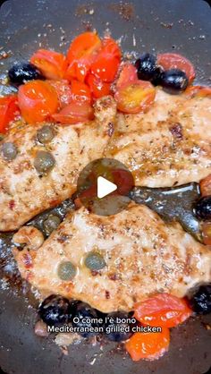 two pieces of meat with tomatoes and olives cooking in a pan