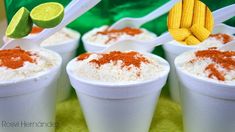 four cups filled with different types of food and garnished with corn on the cob