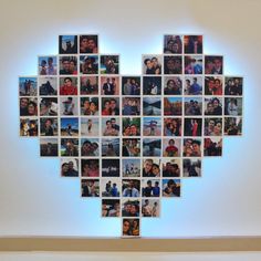 a heart made up of many different people's faces on a white wall with blue lighting