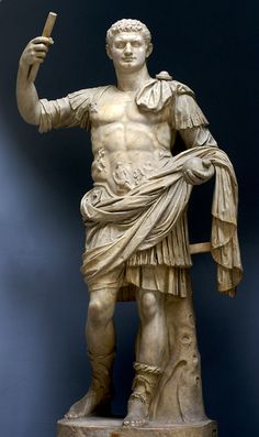 a statue of a man holding a stick in his right hand and pointing to the left