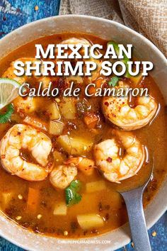 mexican shrimp soup in a white bowl on a blue tablecloth with a spoon next to it