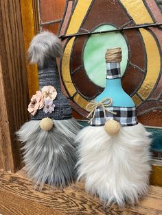 two stuffed animals sitting on top of a window sill next to a wine bottle