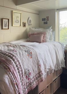 a bed with white sheets and pink pillows