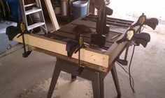 a table saw is being worked on in a garage with tools attached to the bench