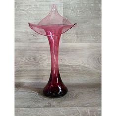 a pink vase sitting on top of a wooden floor