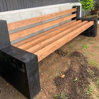 a wooden bench sitting on top of a dirt field