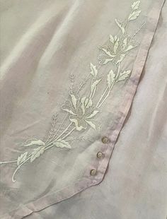 an embroidered shirt with white flowers on it