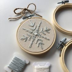 the embroidery is being worked on with scissors and thread to make it look like snowflakes