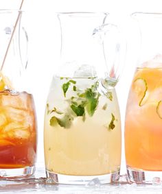 three pitchers filled with different types of drinks