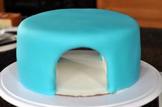 a blue cake sitting on top of a white plate