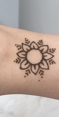 a woman's arm with a small tattoo design on the left side of her arm