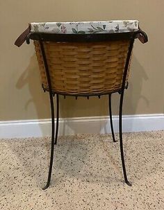 a wicker table with a basket on top and a pillow under the seat cushion