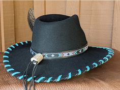 The Twilight felt hat is 100% wool and has a 3.5" brim and 4.25" crown. Hand laced in black and turquoise leather lace. The black leather band features hitched webbing. Decorative large turquoise Concho and Guinea feather completes the hat. Note: All hats are made to order. Please allow up to 4 weeks for your hat to ship. Black Felt Hat With Flat Crown For Ranch, Custom Black Brimmed Felt Hat, Southwestern Black Hat Bands For Country Events, Southwestern Black Hat With Short Brim, Black Felt Hat With Flat Crown For Country Events, Custom Fitted Black Hat Bands, Black Southwestern Style Hat For Festival, Custom Black Hat Bands For Ranch, Southwestern Style Black Hat For Festivals