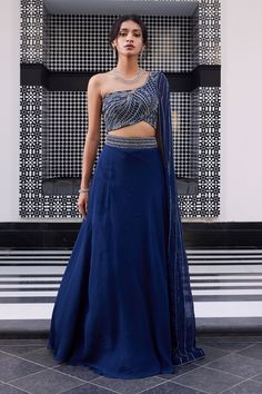 Electric blue one shoulder embroidered blouse with linear work and embellished side palla blouse. Comes with lehenga with slit and embroidered waistband.
Component: 2
Pattern: Embroidered
Type Of Work: Linear
Neckline: Asymmetric
Sleeve Type: One side draped
Fabric: Blouse: Silk, Lehenga: Organza
Color: Blue
Other Details: 
Linear embroidery
Asymmetric neckline
Note: The neckpiece worn by the model is not for sale
Occasion: Sangeet - Aza Fashions One Side Sleeve Blouse Lehenga, One Sided Blouse Design, One Side Blouse Designs, One Side Sleeve Blouse, Blue Sangeet Outfit, One Side Shoulder Blouse, Sangeet Outfit For Bridesmaid, One Shoulder Lehenga, Lines Embroidery