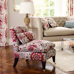 a living room scene with focus on the arm chair and footstool in the foreground