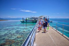 some people are standing on a pier by the water