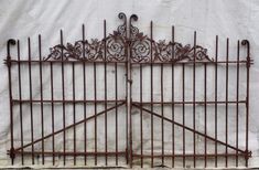 an old iron gate is shown against a white wall