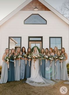 a bride and her bridal party in front of a white house with the sun shining down