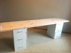 a white desk with two drawers in an empty room