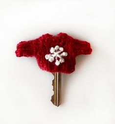 One hand knitted key sweater in solid red yarn with embroidered white snowflake.  Fits over most keys. Included: a lobster claw clasp and key ring to attach to the back neck of the sweater. The neck edging is crocheted. Interested in multiples of this item or a different color or size ? Just convo me.  SIZE: approximately Across chest: 1 inch ( 2.54 cm.) Sleeve to Sleeve:  2 inches  Tall: 1 inch ( 2.54 cm.) My items are made in a non-smoking, pet-friendly home. To visit My Shop: http://www.etsy.com/shop/lauraprilltoo Colors on the monitor may vary slightly from the original. Thanks for stopping by! © Laura Prill As the artist and copyright holder, I retain all rights to reproduce the image for display purposes. Key Sweater, Rouge Uni, Red Yarn, Solid Red, White Snowflake, Lobster Claw, Key Ring, Halloween Shopping, Keychains