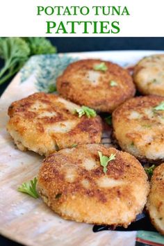 some food that is on a plate and has green leaves around it with the words potato tuna patties