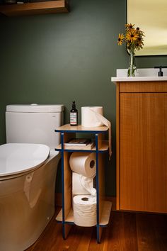 a bathroom with green walls and wooden floors